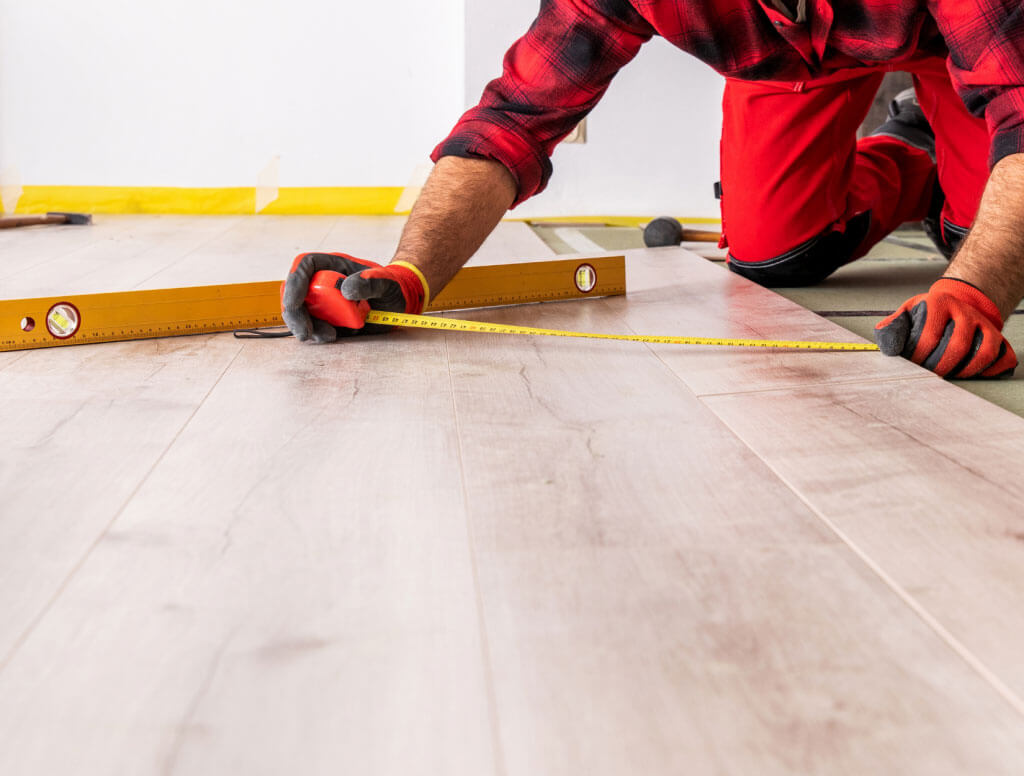 Man measuring and installing flooring, Huddersfield